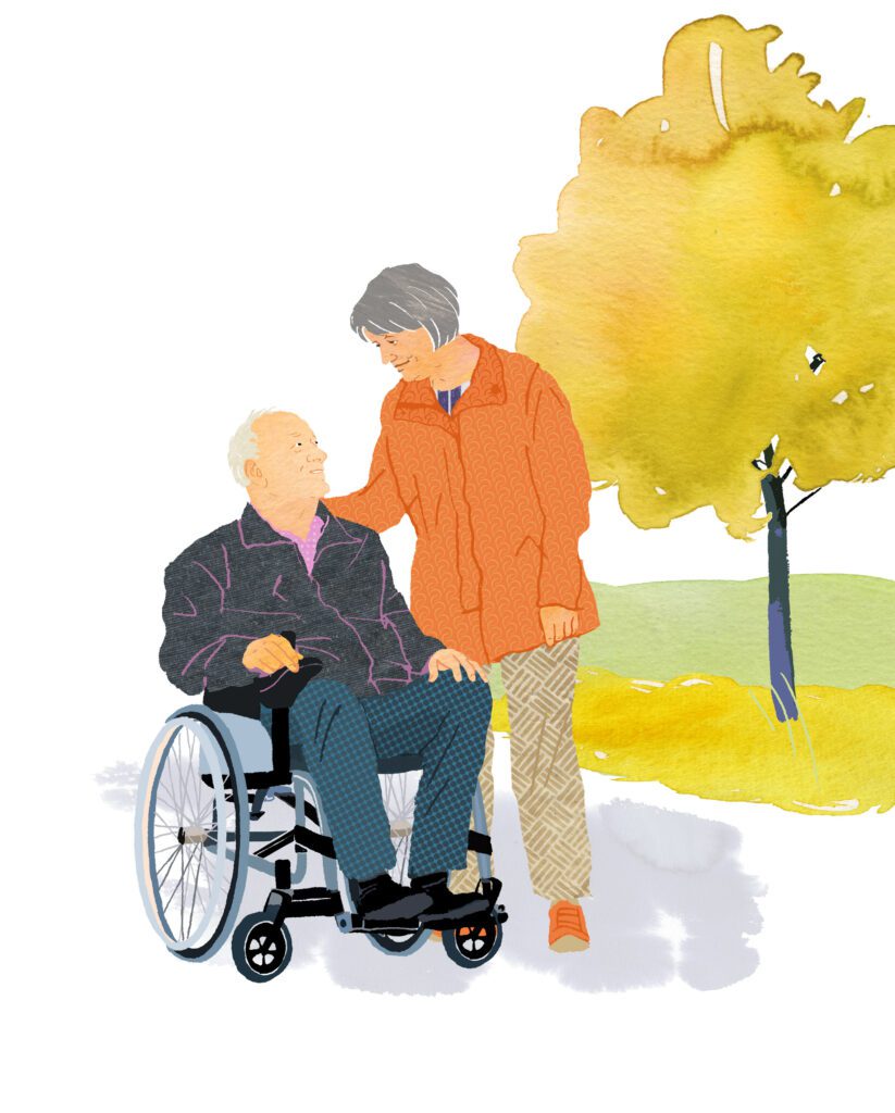 Woman supporting her husband in wheelchair outdoors in a palliative care setting