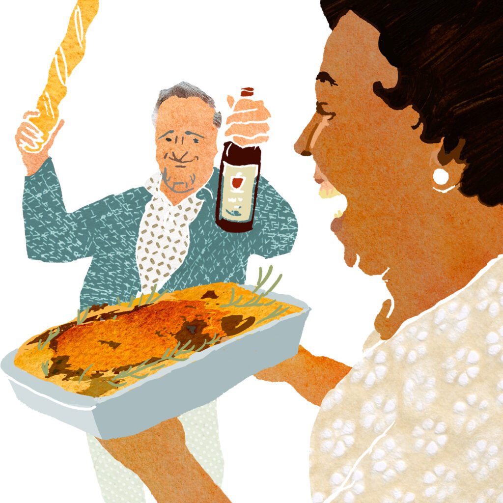 Woman holding a casserole dish, man behind her holding a baguette and a bottle