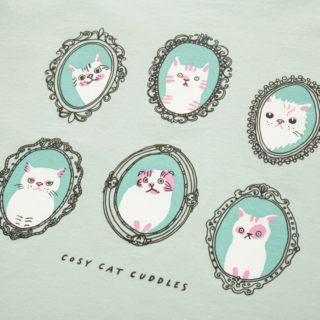 Close-up of cat cameo illustration print on mint green Uniqlo Kids T-shirt by Marie Åhfeldt.
